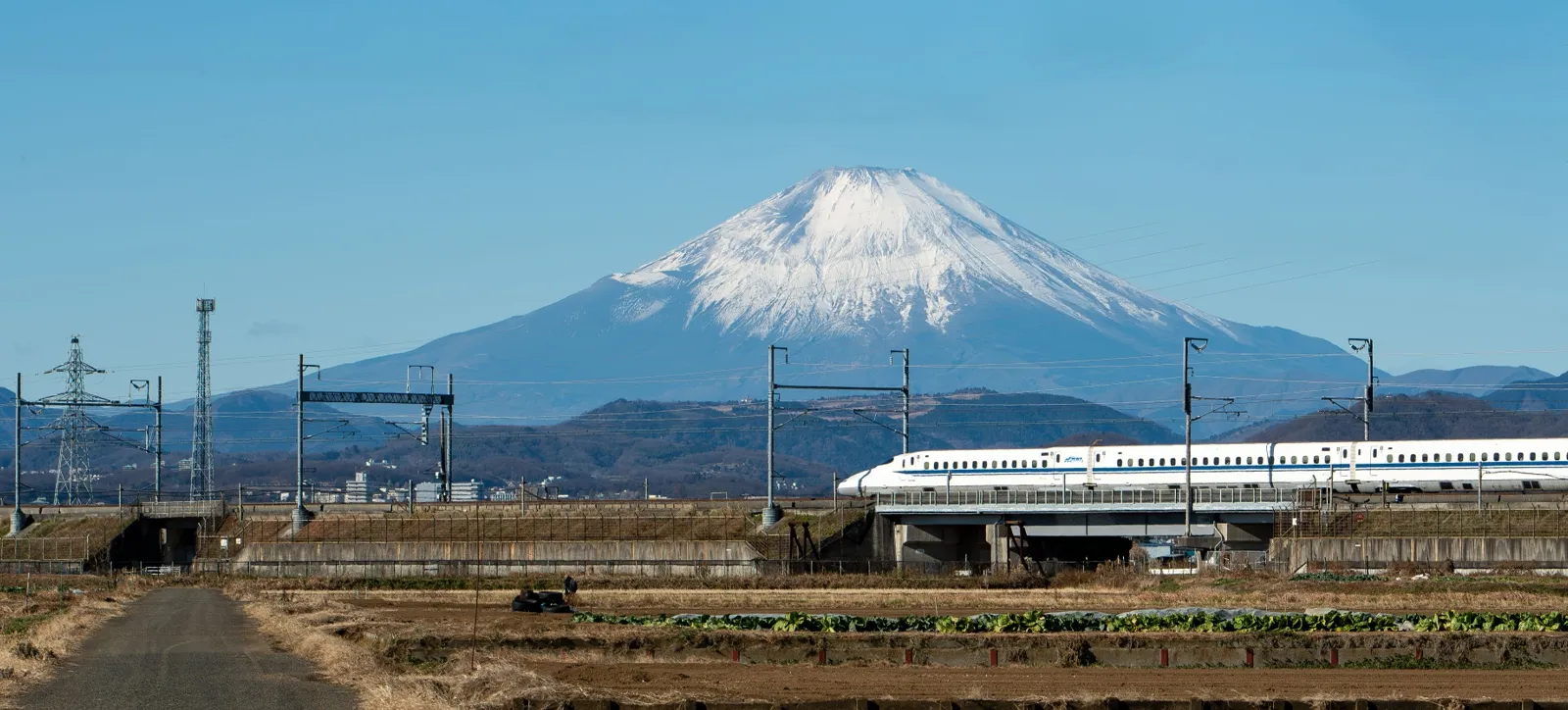 Shinkansen bullet train traveling between Tokyo and Kyoto with Mount Fuji in the background